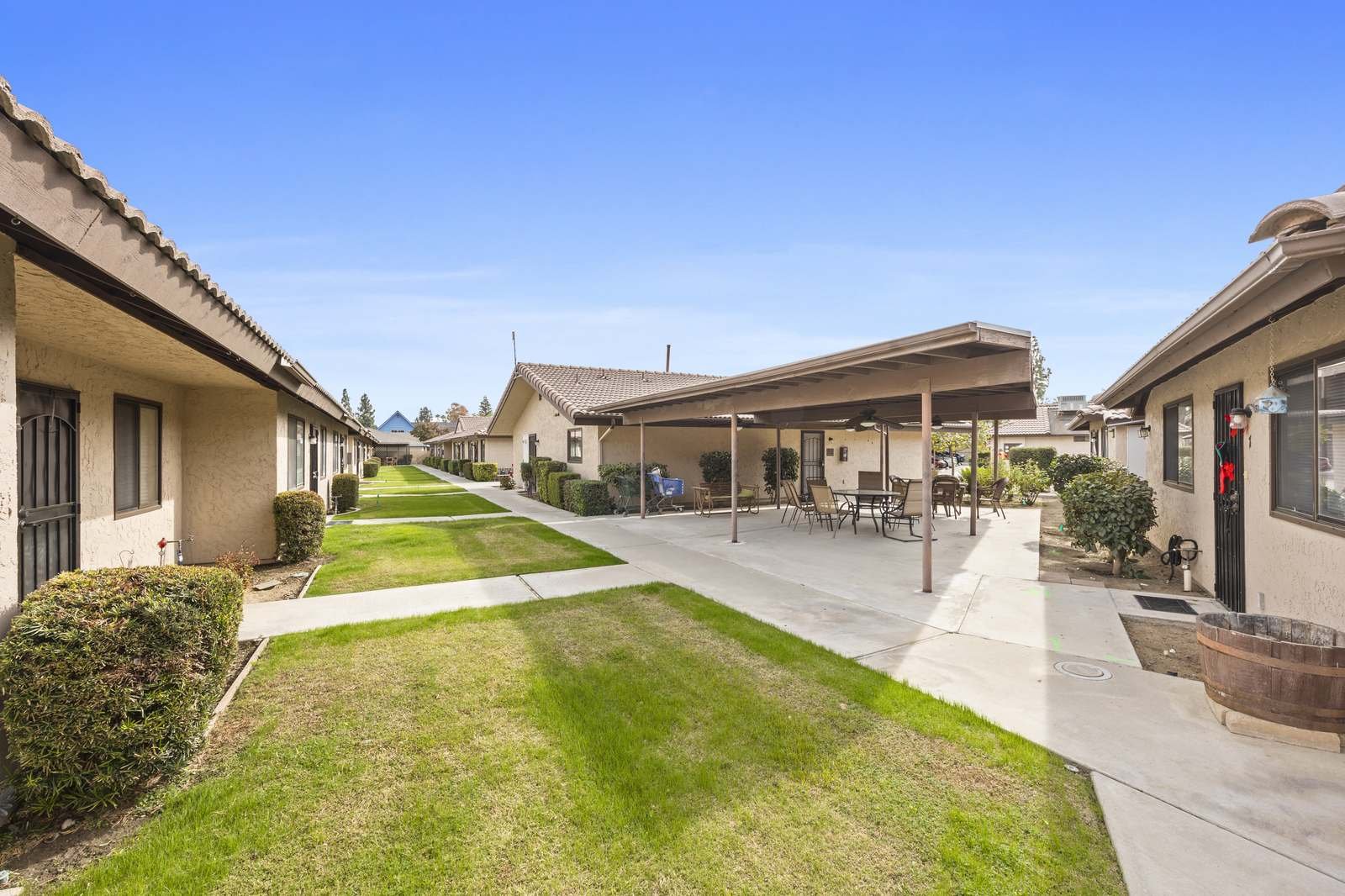 Tree-lined walkway between single-story homes at The Manors