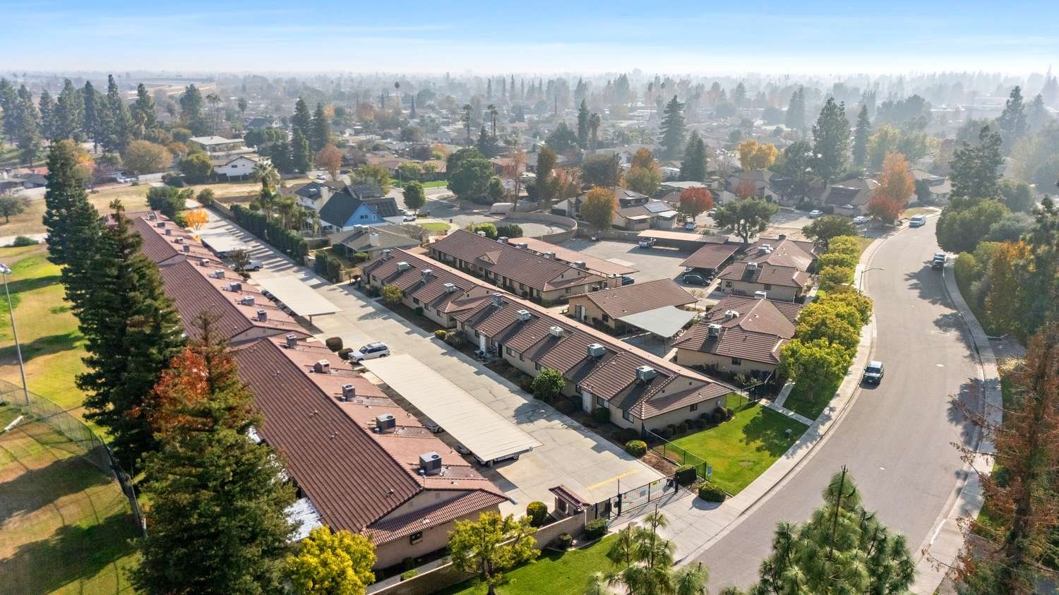 Aerial view of The Manors community showing tile-roofed homes and mature trees